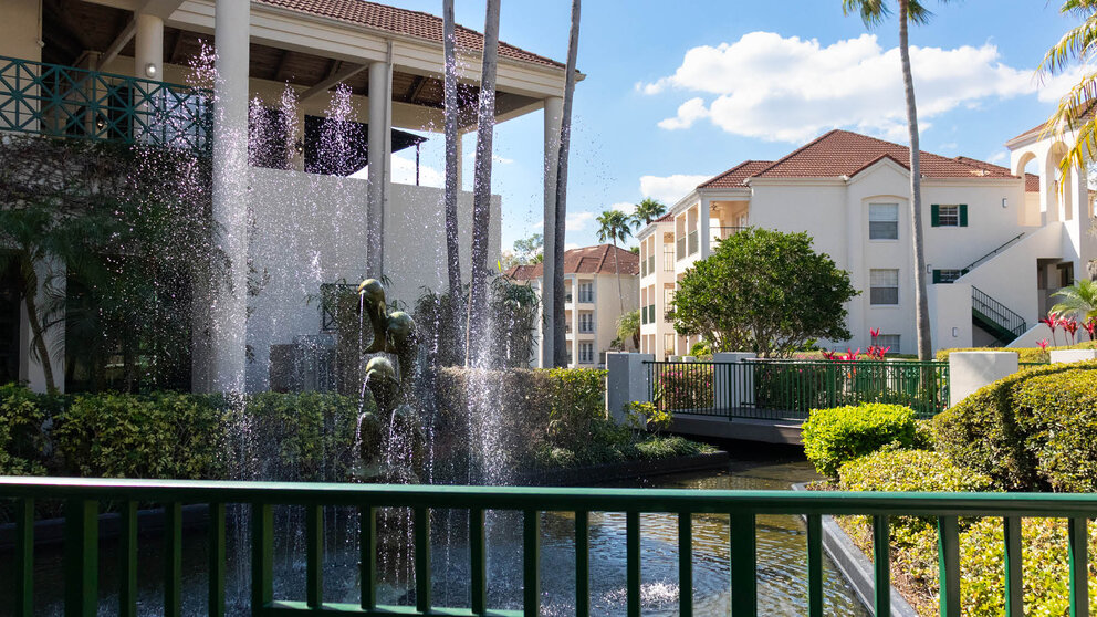 a fountain in a courtyard with buildings in the background