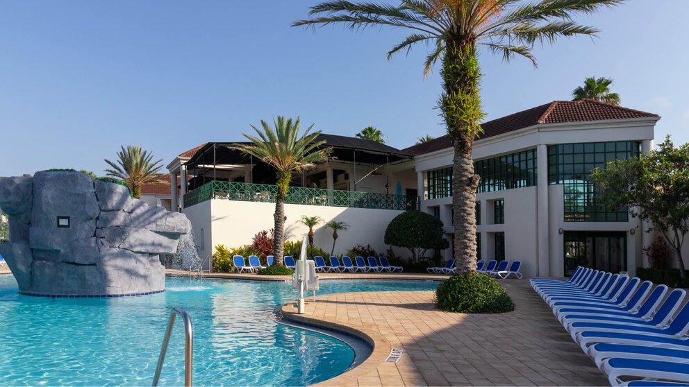 a pool with a fountain and palm trees