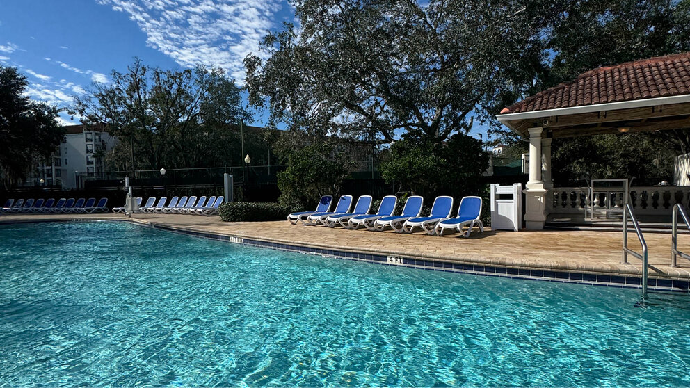 a pool with chairs and trees