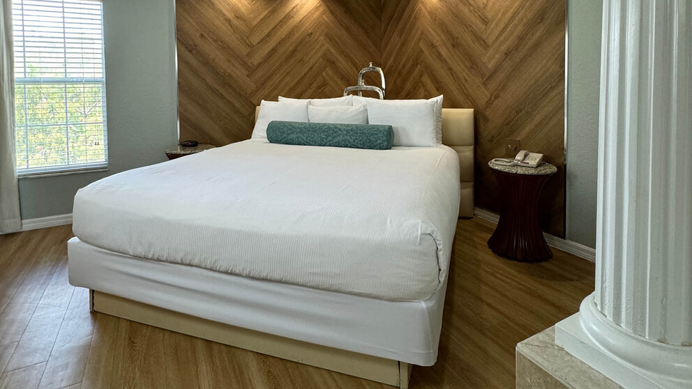 a bed with a wood paneled wall