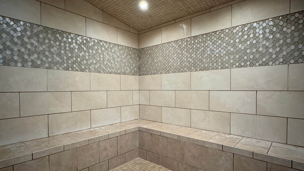 a tiled shower with a bench