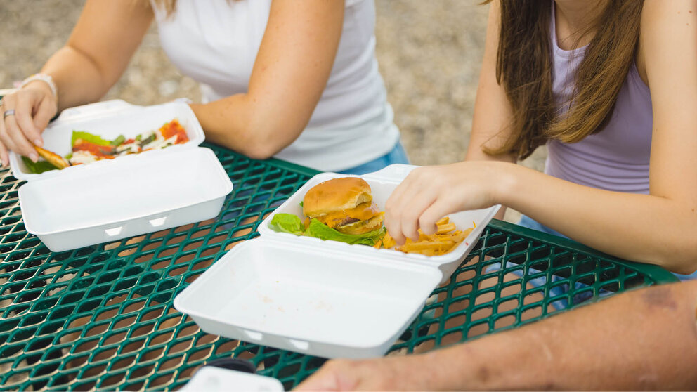 a woman eating food at a picnic table